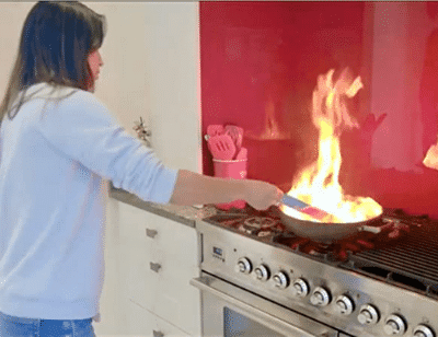 woman putting sachet in pan fire