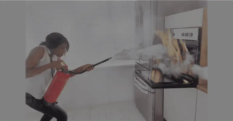 Woman using a fire extinguisher in the kitchen