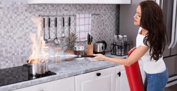 best fire extinguishers for the home. women extinguishing a pan fire